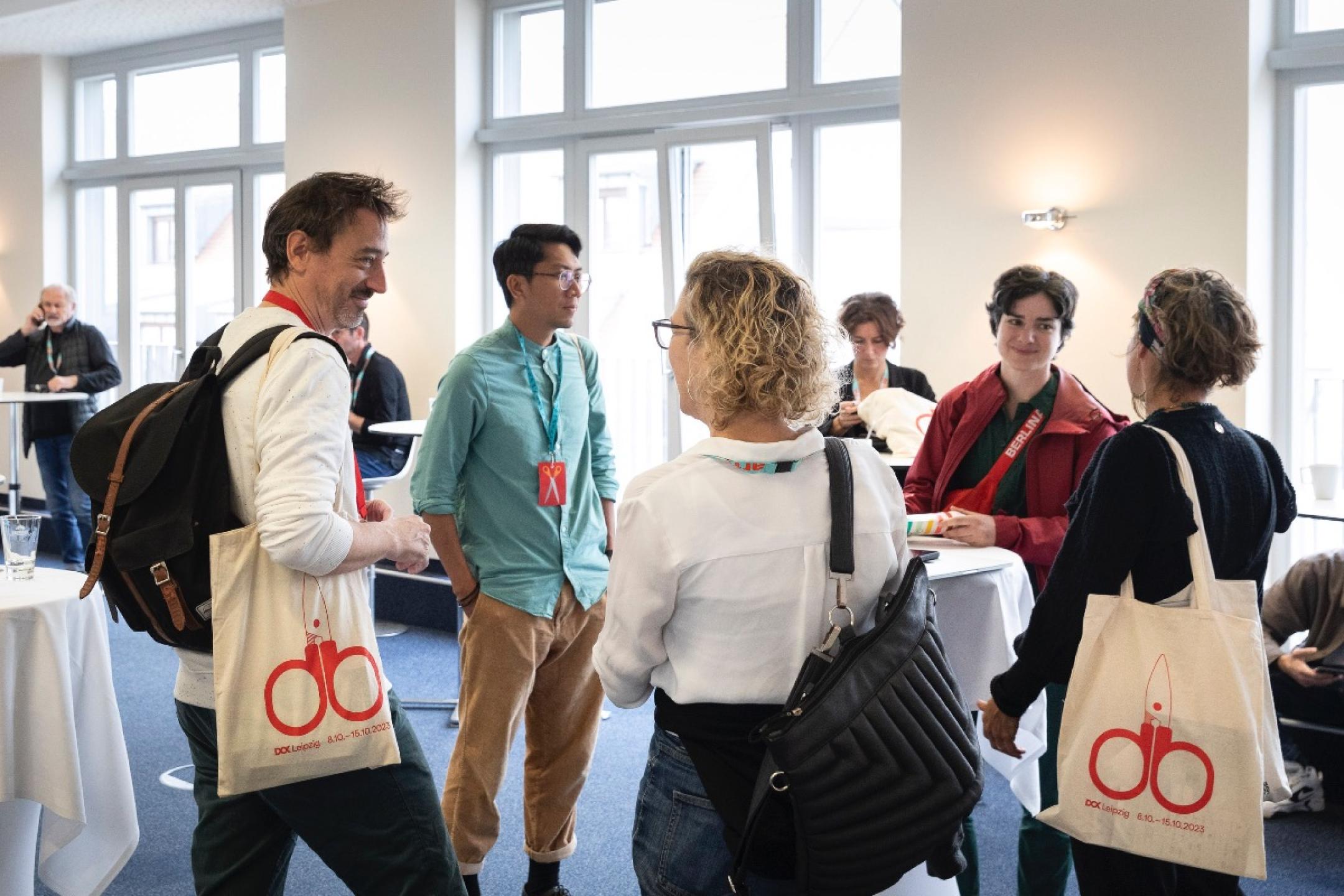 A group of people carrying Dok Leipzig bags 