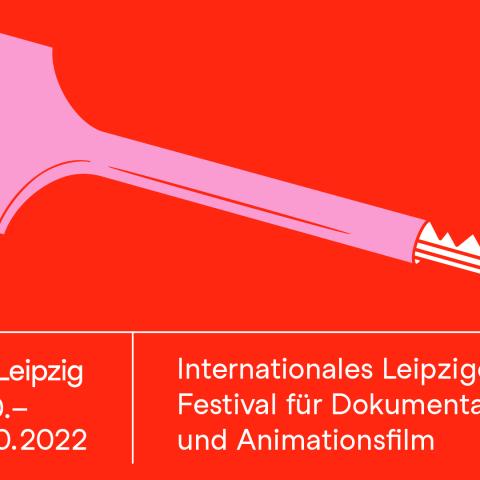 The festival’s key visual shows a classic key to a GDR apartment in pink on a red background.