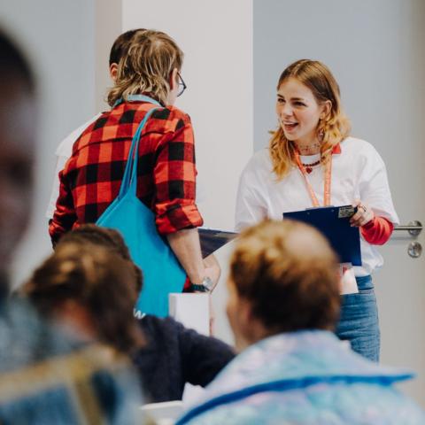 Eine Volunteer im Gespräch mit DOK Industry Besuchern.