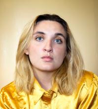 Portrait of Emily Rogers in a shiny yellow shirt