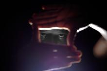 Mungai Kiroga's eyes framed by his hands against the light