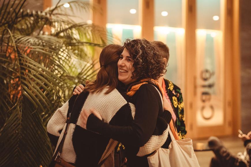 cozy photo of two people embracing in a cafe foyer