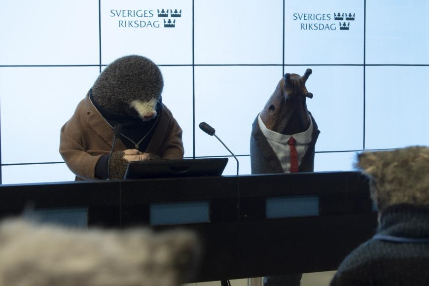 Ein animierter Maulwurf und Schnecke geben eine Pressekonferenz